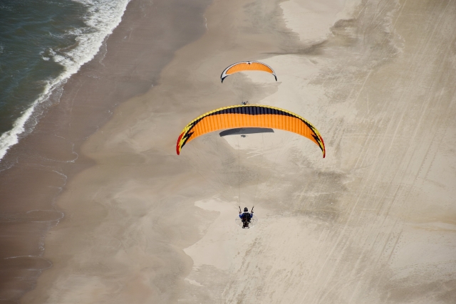 Vuela sobre la playa en paramotor