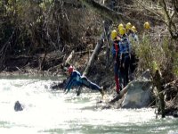  ein Mann wirft sich ins Wasser und eine Gruppe von Menschen wartet am Ufer 