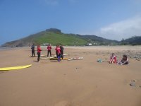 Surfistas charlando con los monitores en la arena