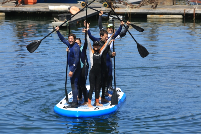 saludando sobre tabla de paddle surf