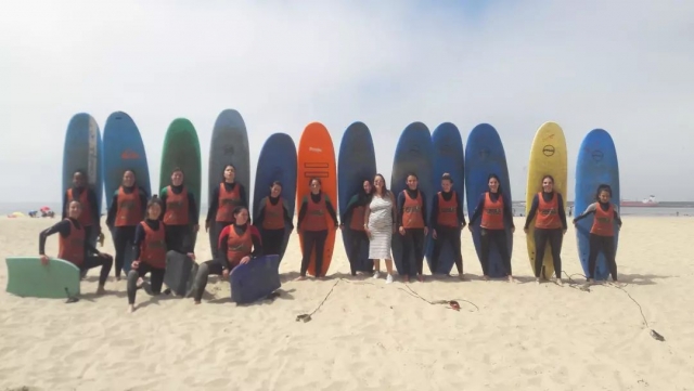 Um grupo de surfistas posando com suas respectivas pranchas 