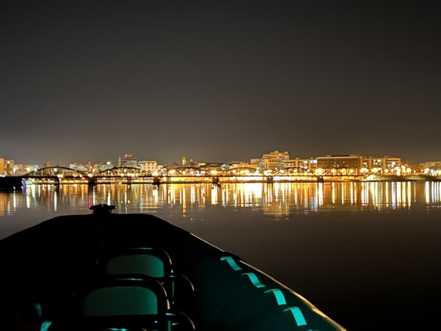  Di notte sulla barca, con la città illuminata sullo sfondo 