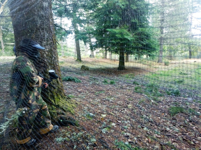  Um utilizador atrás da rede que delimita o perímetro do palco de paintball 