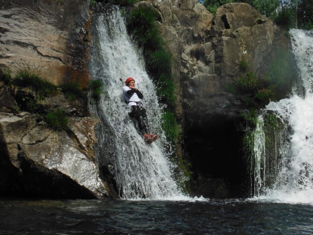 Einen natürlichen Wasserfall hinunterrutschen 