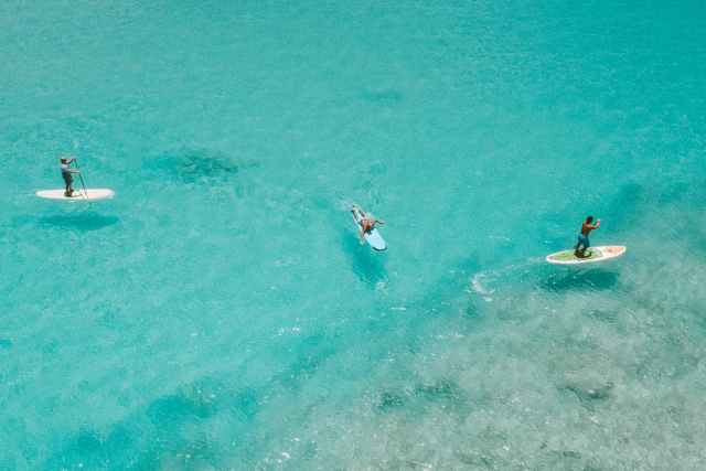  在水晶般清澈的海水中划桨冲浪 