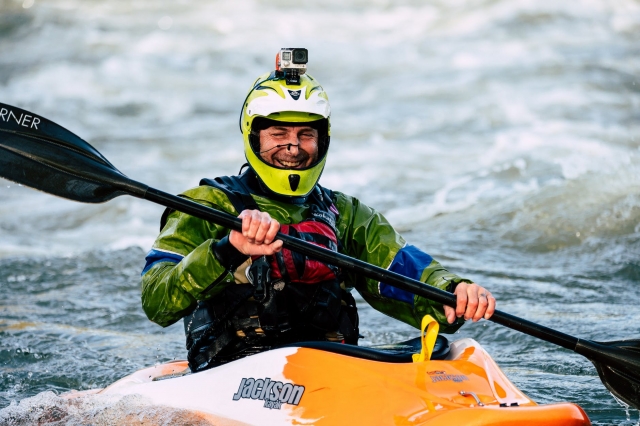 Hombre remando en canoa con camara