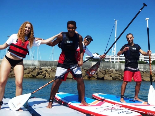  Eine Gruppe von Freunden steht auf den Paddelsurfbrettern 