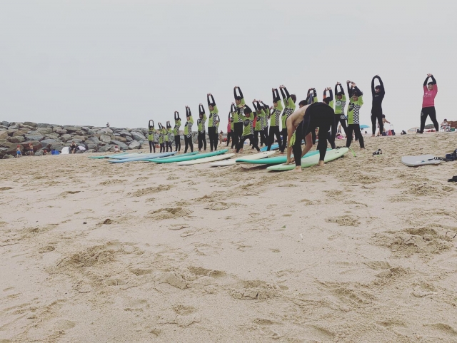  Faire des exercices d'étirements sur la plage avec les petits 