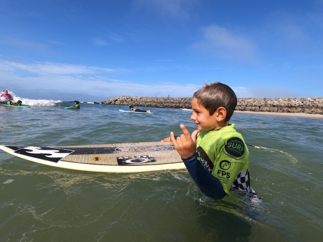  Un petit dans l'eau content de sa planche 