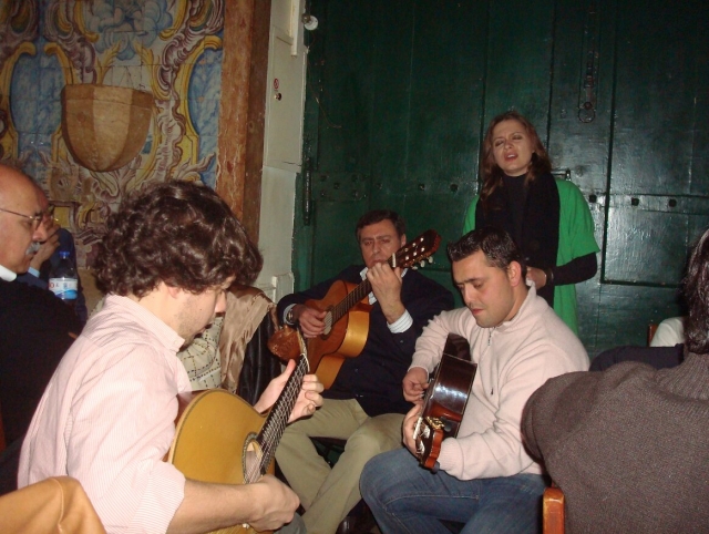 Una mujer cantante acompañada de varias guitarras