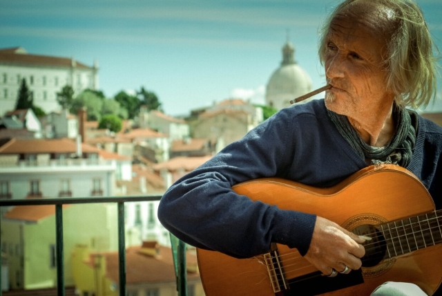 Un hombre mayor practicando con la guitarra