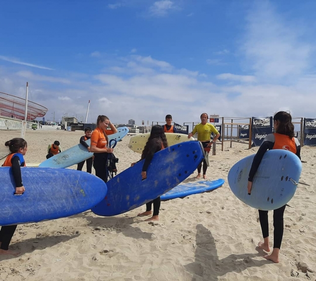  Les enfants portent leurs planches respectives sur la plage 