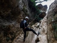 Rappeling supporting your feet on the rock